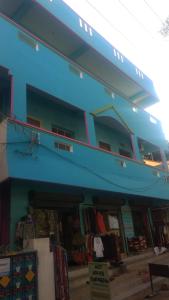 un edificio azul con una tienda delante en Vijaya Guest House en Tiruvannāmalai