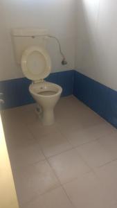 uma casa de banho com WC num quarto azul e branco em Vijaya Guest House em Tiruvannāmalai