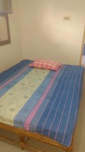 a bed in a bedroom with a blue bedsheet at Vijaya Guest House in Tiruvannāmalai