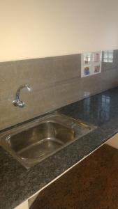 a kitchen counter with a stainless steel sink at Vijaya Guest House in Tiruvannāmalai