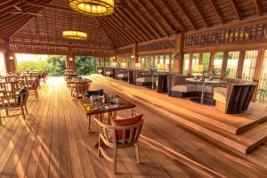 a restaurant with wooden floors and tables and chairs at Hurawalhi Island Resort in Kuredu