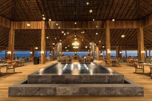 a restaurant with a pool in the middle of a room at Hurawalhi Island Resort in Kuredu