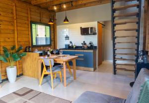 a kitchen with a table and a dining room at Chalé em laguna in Pescaria Brava