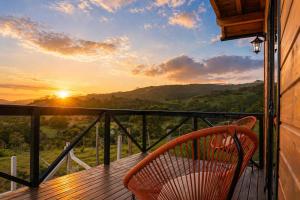 a chair sitting on a balcony with a sunset at Chalé em laguna in Pescaria Brava