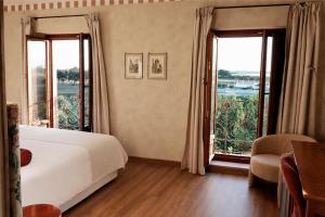 a bedroom with a bed and two large windows at Posada San Miguel Arcángel Experience in Arévalo