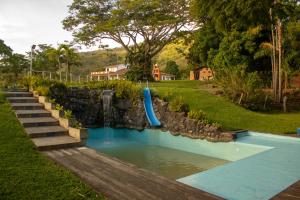 a pool with a blue slide in a yard at Alma Terra Campestre in Ginebra