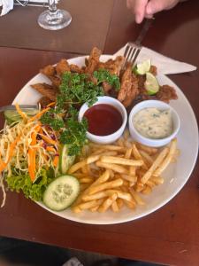 a plate of food with french fries and dips at Goldern Gate in Kandy