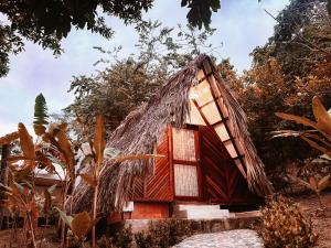 a small house with a thatched roof at Glamping Kunna Tayrona in El Zaino