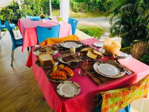 a table with plates of food on a red table cloth at Goldern Gate in Kandy