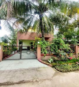 a palm tree in front of a house with a gate at Royal Palace in Dhaka