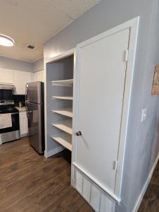an open door to a kitchen with a refrigerator at Entire One Bedroom Condo with AC, Wifi, & Pool in San Antonio +5 photos