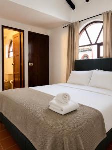 a bedroom with a bed with two towels on it at Hostel Once Once in Villa de Leyva