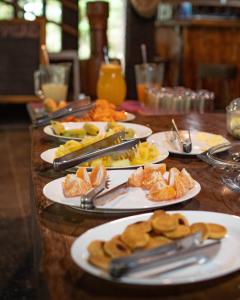 a wooden table with plates of food on it at Hotel de selva EL PUENTE in Villa Tunari