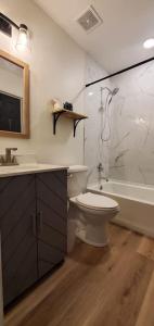 a bathroom with a toilet and a sink and a tub at On Golf Course Peaceful Central Upscale in Columbus +22 photos