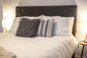 a bed with white sheets and pillows on it at Golf Course Views, Sunsets & Chill Vibes in Columbus