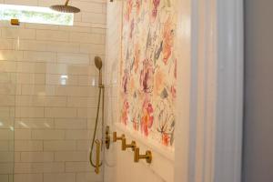 a shower with a painting on the wall in a bathroom at The Tea CottageStylishRain ShowerLocation in Starkville
