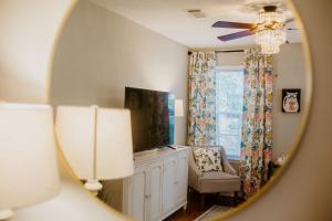 a mirror reflecting a room with a chair and a window at The Tea CottageStylishRain ShowerLocation in Starkville