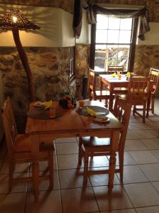 uma sala de jantar com uma mesa de madeira e cadeiras em Centurion Guest House and Lodge em Centurion