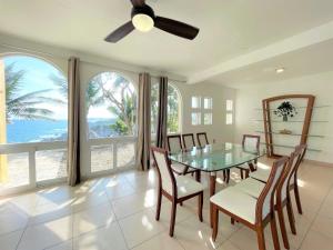 a dining room with a table and chairs and windows at Villas & Resort Luz de Luna in Santa Cruz Huatulco