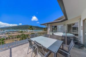 a balcony with a table and chairs and a view of the ocean at at Boathaven Bay Holiday Apartments in Airlie Beach