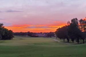 a sunset on a golf course with trees in a field at Golf-Side Retreat Calm Central Stylish in Columbus