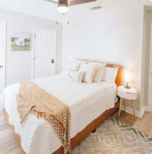 a white bedroom with a bed with white sheets and pillows at Golf-Side Retreat Calm Central Stylish in Columbus