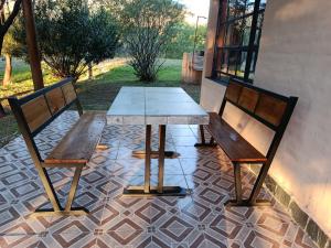 a wooden table and two chairs on a patio at Cabaña La Escondida in Villa de la Quebrada