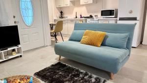a blue couch with yellow pillows in a living room at Tree House in Saint Martin