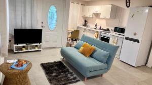 a living room with a blue couch and a kitchen at Tree House in Saint Martin