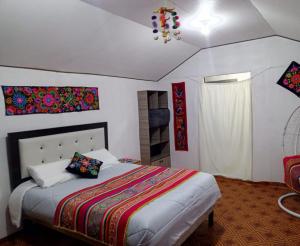 a bedroom with a bed and a chandelier at Uros titikaka Golden Lodge in Puno