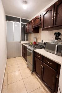 a kitchen with wooden cabinets and a stove top oven at Casa Mezquite in Ocotlán