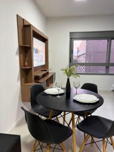 a dining room with a table and chairs and a television at Loft with pool and garage, next to Bourbon in Porto Alegre