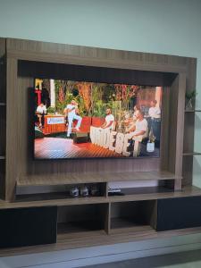 a flat screen tv sitting on top of a entertainment center at Loft with pool and garage, next to Bourbon in Porto Alegre