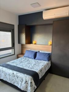 a bedroom with a large bed with blue pillows at Loft with pool and garage, next to Bourbon in Porto Alegre +46 photos