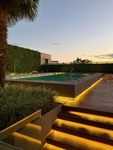 a backyard with a swimming pool with stairs and lights at Loft with pool and garage, next to Bourbon in Porto Alegre