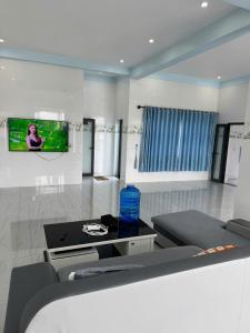 a living room with a couch and a tv on the wall at KEN Homestay in Cu Lao Thu