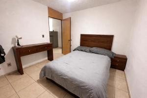 a bedroom with a bed and a dresser in it at Casa mezquite in Ocotlán