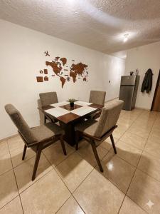 a table and chairs in a room with a map on the wall at Casa mezquite in Ocotlán
