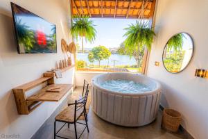 a large tub in a room with a window at Wafeh Pampulha Suítes in Belo Horizonte
