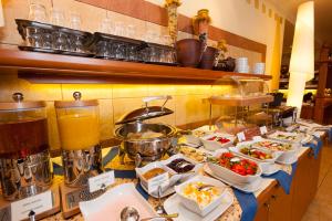 a buffet line with plates of food on a table at Hotel Partner in Warsaw