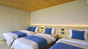 three beds in a room with blue and white at KONA OCEAN Club in Awaji +25 photos