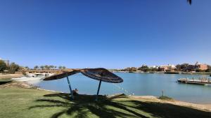 a person sitting under two umbrellas next to a river at Golf El Gouna 2 in Hurghada