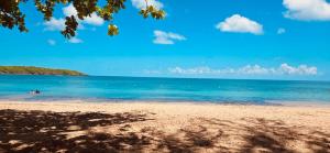 a beach with people swimming in the ocean at Comfortable Apartment in the Greater Ponce Area in Ponce