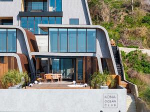 a modern house with glass windows and a patio at KONA OCEAN Club in Awaji