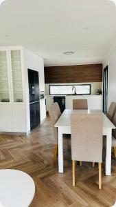 a kitchen and dining room with a white table and chairs at Resort-style living -pool in Bass Hill