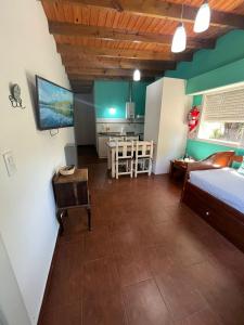 a bedroom with a bed and a table and a kitchen at Cabañas El Viejo Sauce in Tandil