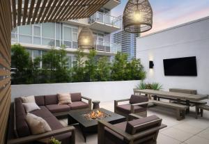 a patio with a couch and tables and a tv at The Margot Hotel San Diego Gaslamp Quarter, Outset by Hilton in San Diego