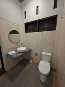 a bathroom with a toilet and a sink and a mirror at Bukit Luwih House in Munduk +31 photos