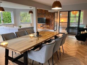 a dining room and living room with a wooden table and chairs at Very large apartment with private sauna in Stężyca