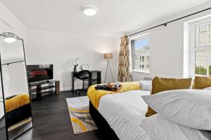 a bedroom with a bed and a desk and a tv at Cheshire Gold- studio apartment, Warrington in Warrington